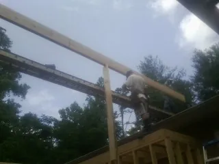 Carpenter setting a ridge beam over a new addition frame — Ice Dam Removal by Roofing Brothers in East Windsor