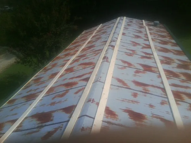Rusted metal roof panels with new wood purlins before replacement — Storm Damage Roof Repair in East Windsor by Roofing Brothers